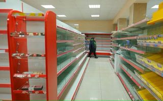 Een vrouw loopt langs lege schappen in een supermarkt in Nagorno-Karabach. Doordat Azerbeidzjan de voedselvoorziening naar de regio blokkeert, dreigt er nu hongersnood.  beeld GDB
