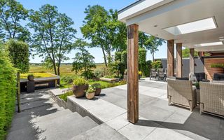 Tuin met overdekt terras en uitzicht op weilanden