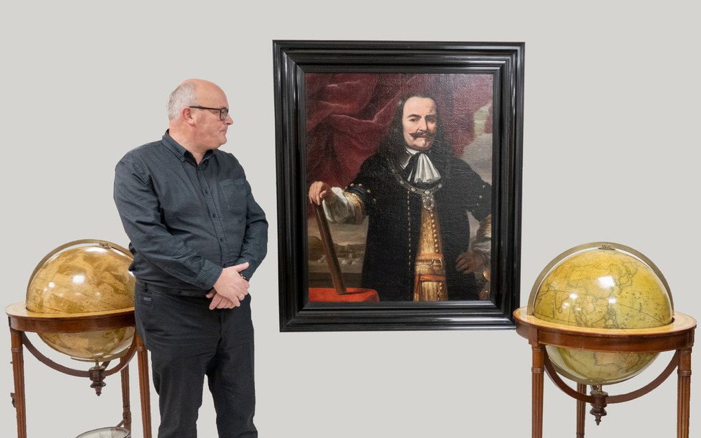 Bart de Roo naast het schilderij van Michiel de Ruyter. Het werk blijkt van Ferdinand Bol te zijn, een leerling van Rembrandt. De Roo biedt het schilderij deze week aan op kunstbeurs PAN in Amsterdam. beeld Antiquariaat De Roo 