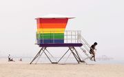 Strand met wachthuisje in regenboogkleuren in Long Beach, Califoranië. beeld AFP, Frederic J. Brown