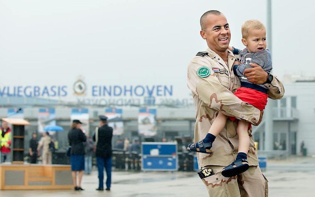 Een militair wordt op vliegveld Eindhoven verwelkomd door zijn kind. beeld ANP, Bart Maat