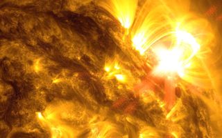 Zonnevlam ontsnapt aan het vurige zonneoppervlak en buigt door het magnetische veld terug naar de zon. beeld NASA