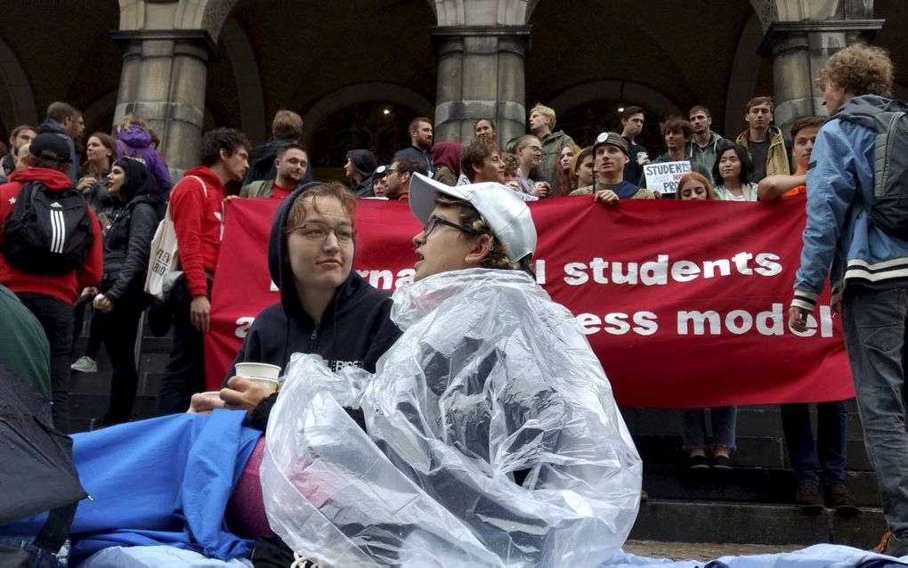 In de regen protesteerden studenten in 2017 tegen het kamertekort voor jongeren uit het buitenland op de trappen van het academiegebouw in Groningen. beeld Universiteitskrant