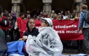 In de regen protesteerden studenten in 2017 tegen het kamertekort voor jongeren uit het buitenland op de trappen van het academiegebouw in Groningen. beeld Universiteitskrant