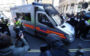 Een arrestantenbusje met daarin Julian Assange. beeld EPA