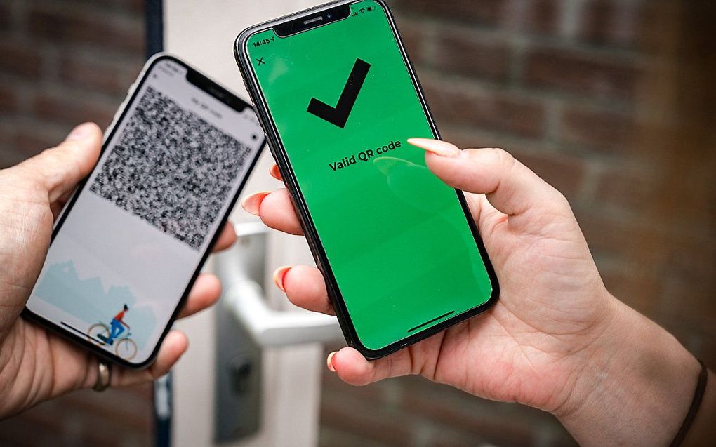 Een telefoon met een groen vinkje in de CoronaCheck app. Op maatschappelijk vlak is discussie ontstaan over het deurbeleid bij niet-gevaccineerden tegen het coronavirus. beeld ANP, Rob Engelaar