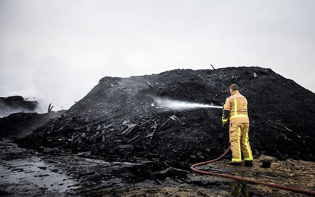 Brandweer bezig met nablussen de dag na de vonkenregen bij de boulevard van Scheveningen die ontstond door het vreugdevuur op het strand. beeld ANP