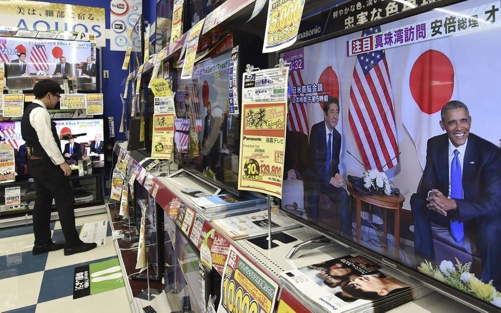 In een winkel voor tv-toestellen in Tokio zijn alle zenders afgestemd op de ceremonie rond de 75-jarige herdenking van de Japanse aanval op Pearl Harbor, waarbij ook de Japanse premier Shinto Abe betrokken was. beeld AFP, Kazuhiro Nogi