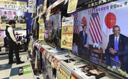 In een winkel voor tv-toestellen in Tokio zijn alle zenders afgestemd op de ceremonie rond de 75-jarige herdenking van de Japanse aanval op Pearl Harbor, waarbij ook de Japanse premier Shinto Abe betrokken was. beeld AFP, Kazuhiro Nogi