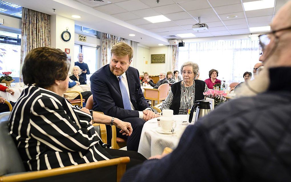 Annie Hollander, overlevende van de Holocaust, laat haar kampnummer zien aan koning Willem-Alexander. beeld ANP