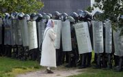 Een demonstrant praat met Wit-Russische politieagenten tijdens een demonstratie om te protesteren tegen de resultaten van de presidentsverkiezingen in Minsk, Wit-Rusland, 13 september 2020. beeld EPA, Stringer