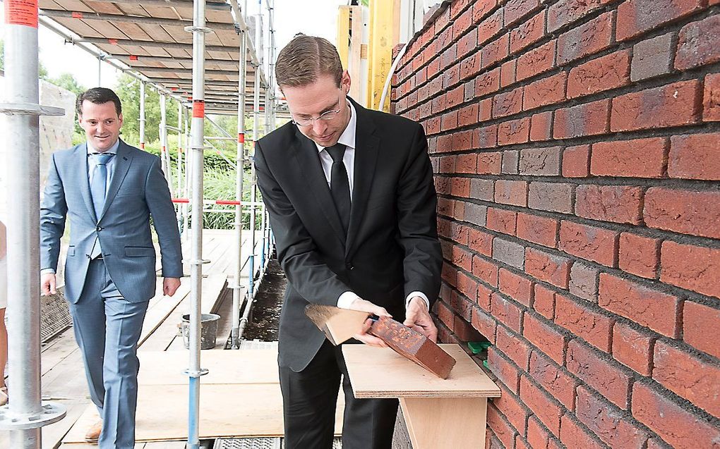 Ds. B. D. Bouman, predikant van de hersteld hervormde gemeente te Stellendam, heeft zaterdagmorgen de eerste steen gelegd van het nieuwe kerkgebouw van zijn gemeente. beeld Henk Copier