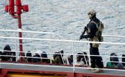 Een Maltese politieman in de haven van Valetta bij een boot met vluchtelingen, eerder dit jaar. beeld AFP