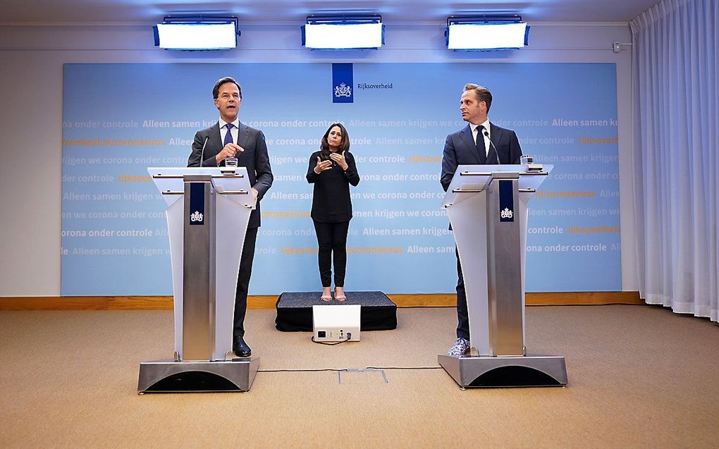 Premier Mark Rutte en Minister Hugo de Jonge van Volksgezondheid, Welzijn en Sport (CDA) en gebarentolk Irma Sluis tijdens de persconferentie na afloop van een overleg van de Ministeriele Commissie Crisisbeheersing (MCCb) over het coronavirus. Beeld ANP, 