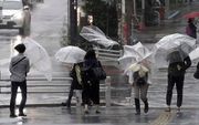Mensen trotseren de regen in Tokyo, Japan. beeld EPA