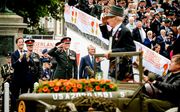 Koning Willem-Alexander neemt het defile af dat door de Haagse binnenstad trekt op de Veteranendag. beeld ANP