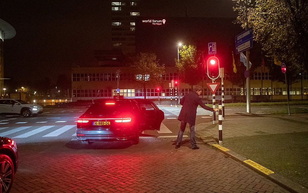 Premier Mark Rutte drukt op het knopje van een verkeerslicht bij zijn vertrek uit het Catshuis, na het langdurige coronaberaad van donderdag. beeld ANP, Bas Czerwinski