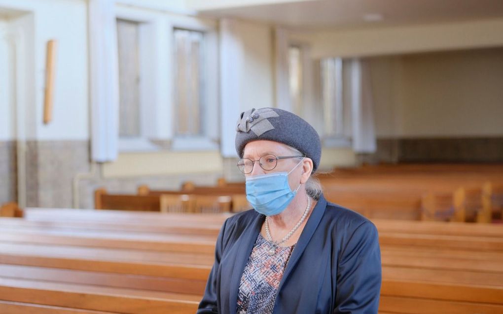 Voor de fotoserie ”Kerk en corona” fotografeerde Sjaak Verboom gemeenteleden in hun kerk. Zij staan op de plaats die zij door de coronacrisis noodgedwongen (tijdelijk) niet konden innemen. Zo verbeeldt de serie wat velen ervaren hebben: een pijnlijke afstand tot hun geestelijke thuis. Foto: Mevrouw N. Roos-Stark (73) in de gereformeerde gemeente te Kampen op de plaats waar haar man, Gerrit Roos, voor het laatst in de kerk zat. Hij overleed kort daarna, in april 2020, aan corona. beeld Sjaak Verboom