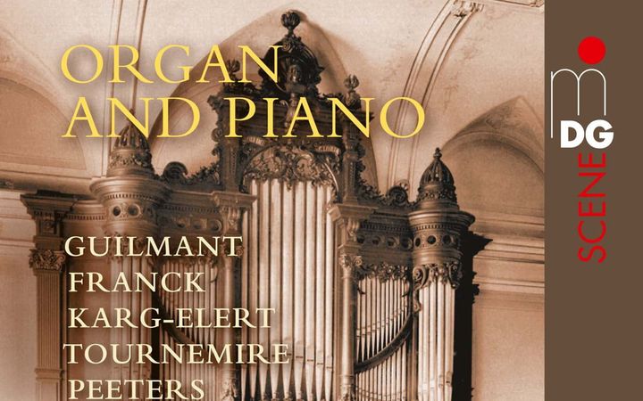 Een klassiek orgelfront met de speeltafel aan de voorzijde staat voor een witte muur.