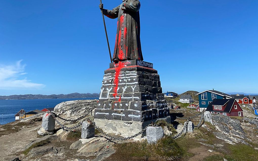 Een met rode verf beklad standbeeld van Hans Egede in Nuuk. beeld AFP