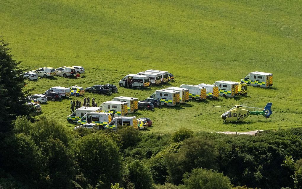 Voertuigen van hulpdiensten staan geparkeerd in de buurt van de treincrash bij Stonehaven, Schotland. beeld AFP