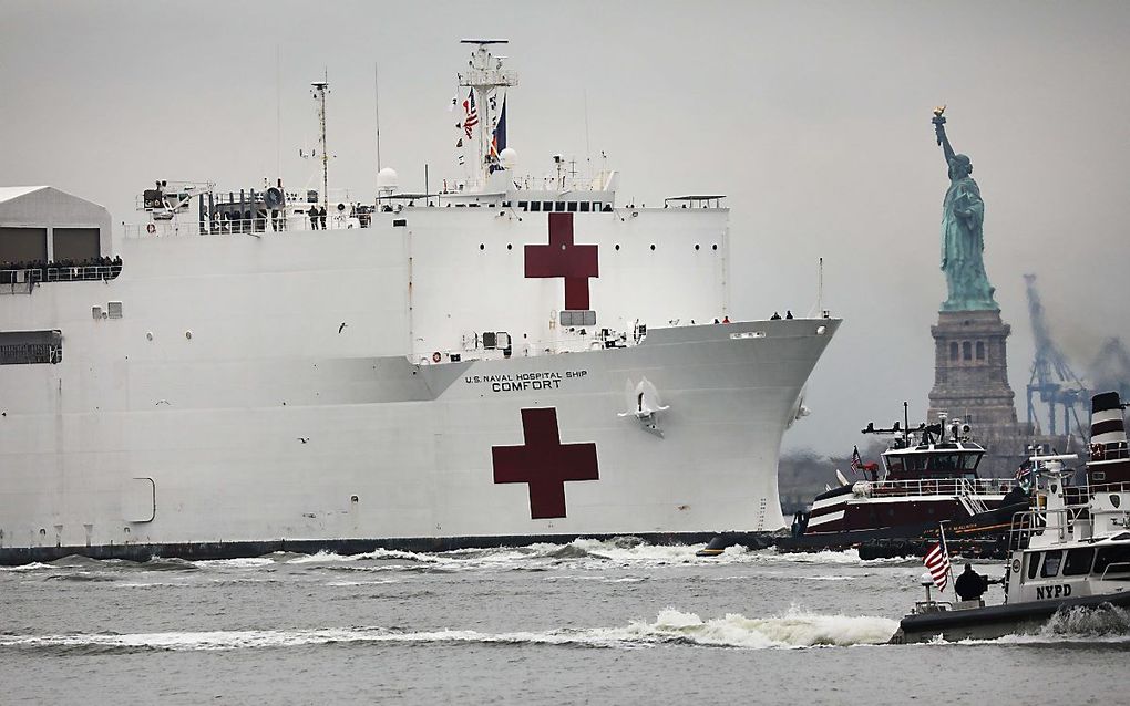 De USNS Comfort van de marine met duizend bedden aan boord passeert het Vrijheidsbeeld. beeld AFP