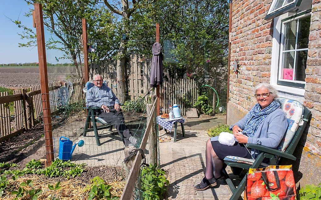 Ries de Visser uit het Zeeuwse Westkapelle krijgt in zijn coronaserre bezoek van zijn dochter Hannie uit ’s Gravenpolder. beeld Dirk-Jan Gjeltema