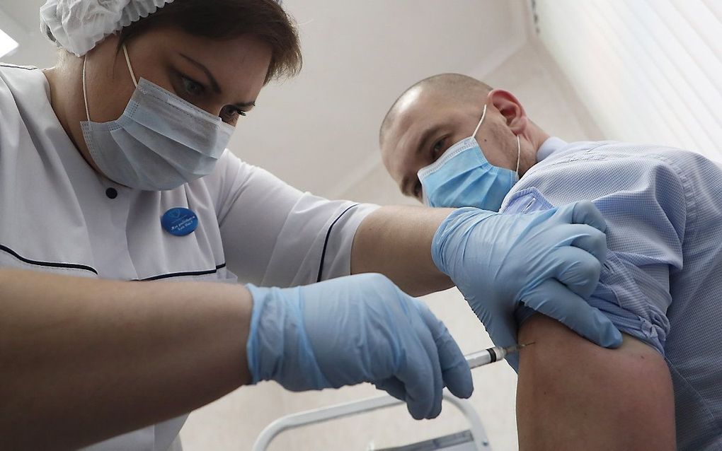 Een Russische verpleegkundige injecteert het Russische coronavaccin. beeld EPA, Maxim Shipenkov