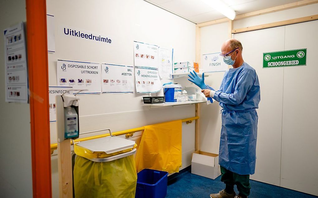 Een medewerker trekt handschoenen aan op de Korte Opname- en Herstelafdeling (KOHA) in het Leids Universitair Medisch Centrum (LUMC). beeld ANP, Bart Maat