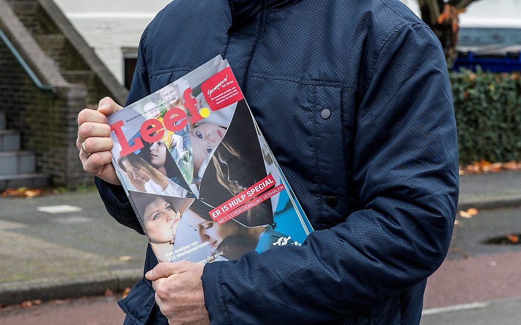 Een waker bij een abortuskliniek met het magazine van Schreeuw om Leven, "Leef". De persoon op de foto heeft geen relatie tot het artikel. beeld RD, Henk Visscher