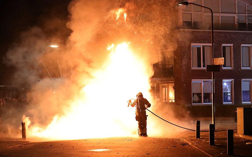 Een brandweerman blust een autobrand in Veen. Bij het blussen van een autobrand is de brandweer in de nacht van vrijdag op zaterdag met zwaar vuurwerk bekogeld. beeld ANP/FPMB, ERIK HAVERHALS