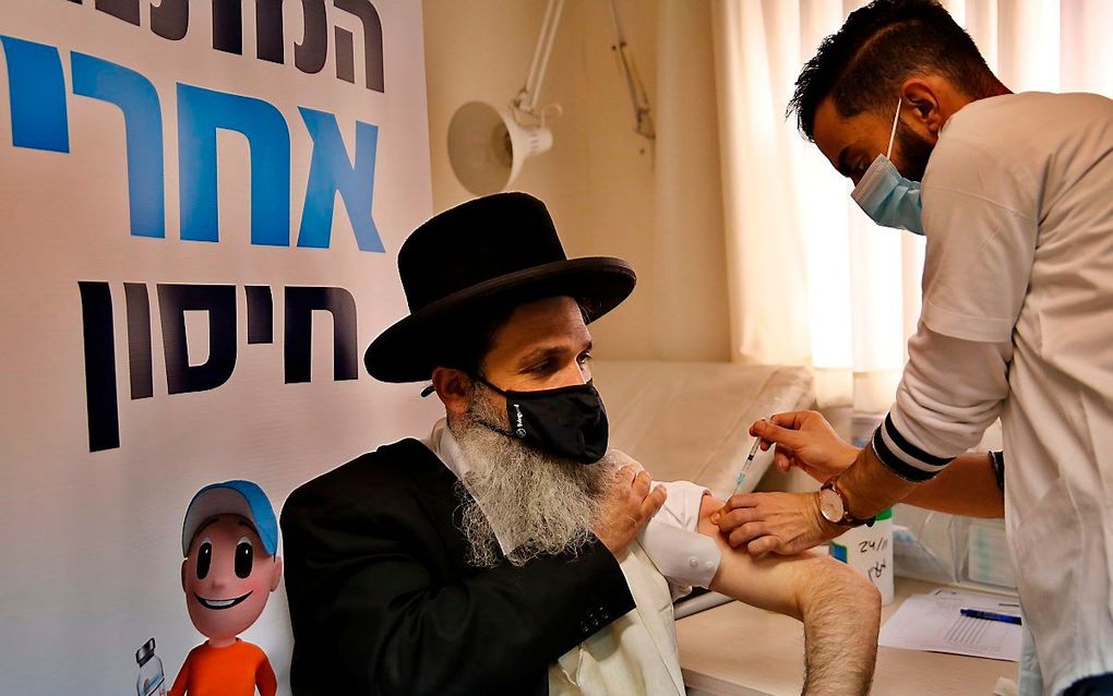 Een orthodoxe Jood wordt gevaccineerd tegen het coronavirus. beeld AFP. Gil Cohen-Magen