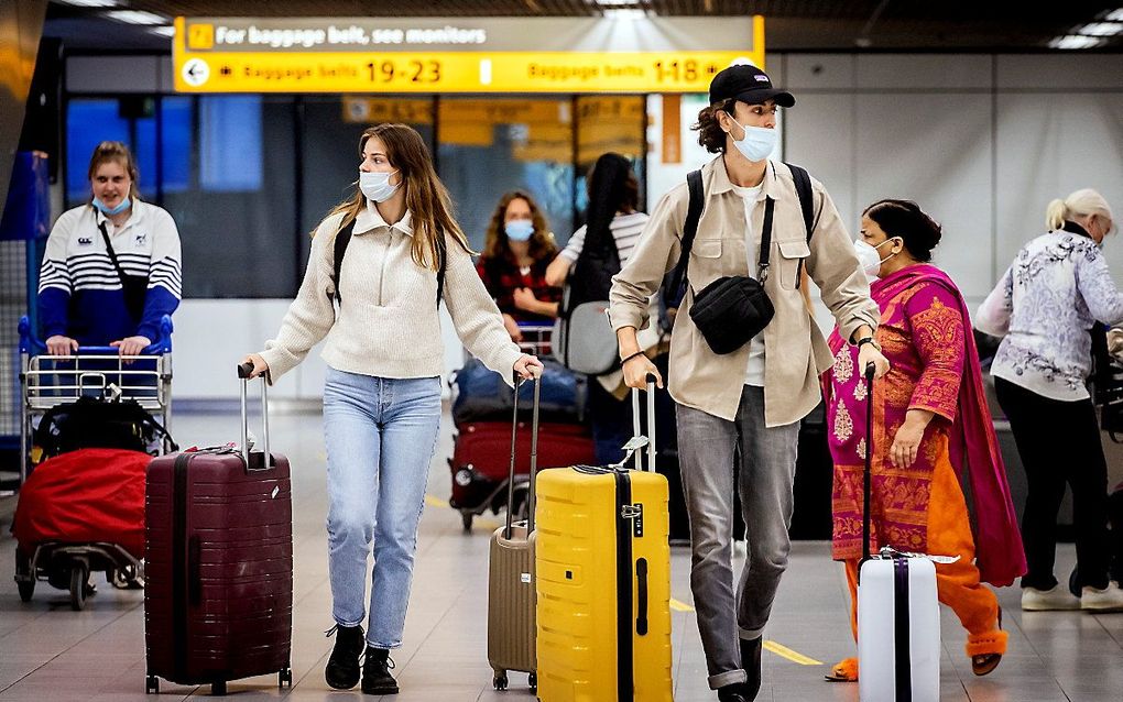 Reizigers met mondkapjes op luchthaven Schiphol. beeld ANP, Koen van Weel