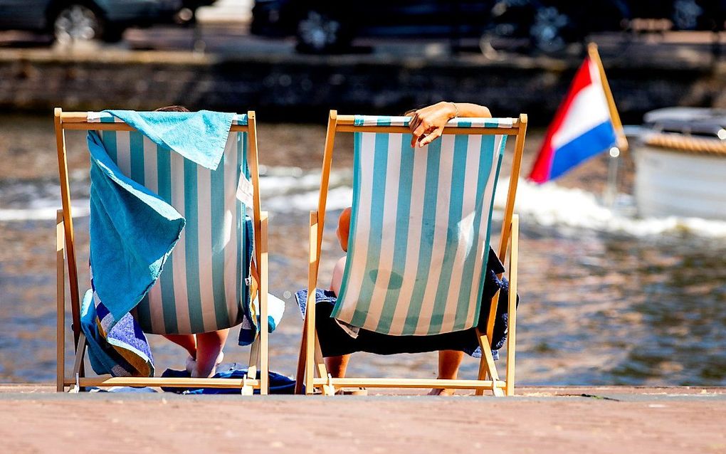 Mensen liggen in een strandstoel tijdens de hittegolf van afgelopen zomer. beeld ANP