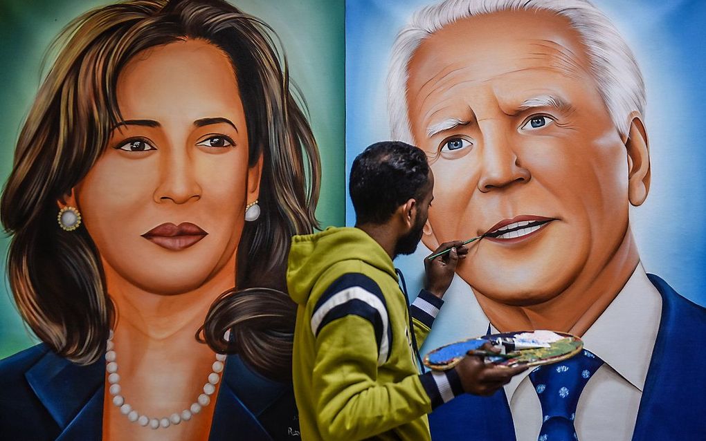 Een Indiase kunstenaar bij een kunstwerk van Joe Biden en Kamala Harris. beeld AFP, Narinder Nanu