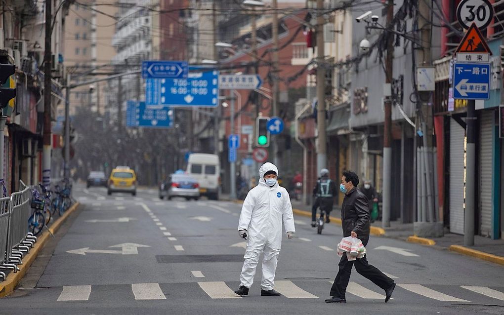 Een man op een zebrapad in de Chinese hoofdstad Shanghai. beeld EPA, Alex Plavevski