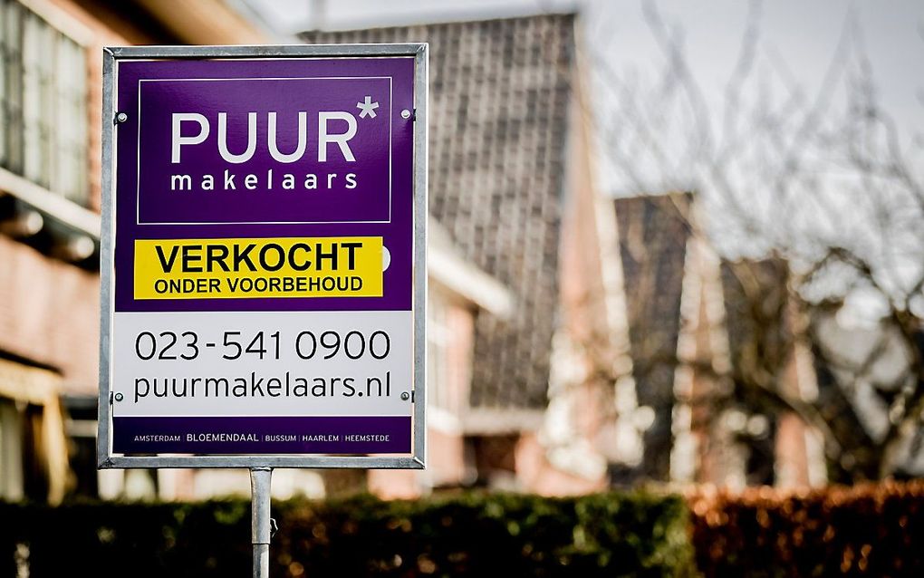 Een verkoopbord van een makelaar in de tuin van een te koop staand huis in Bloemendaal. beeld ANP, Remko de Waal