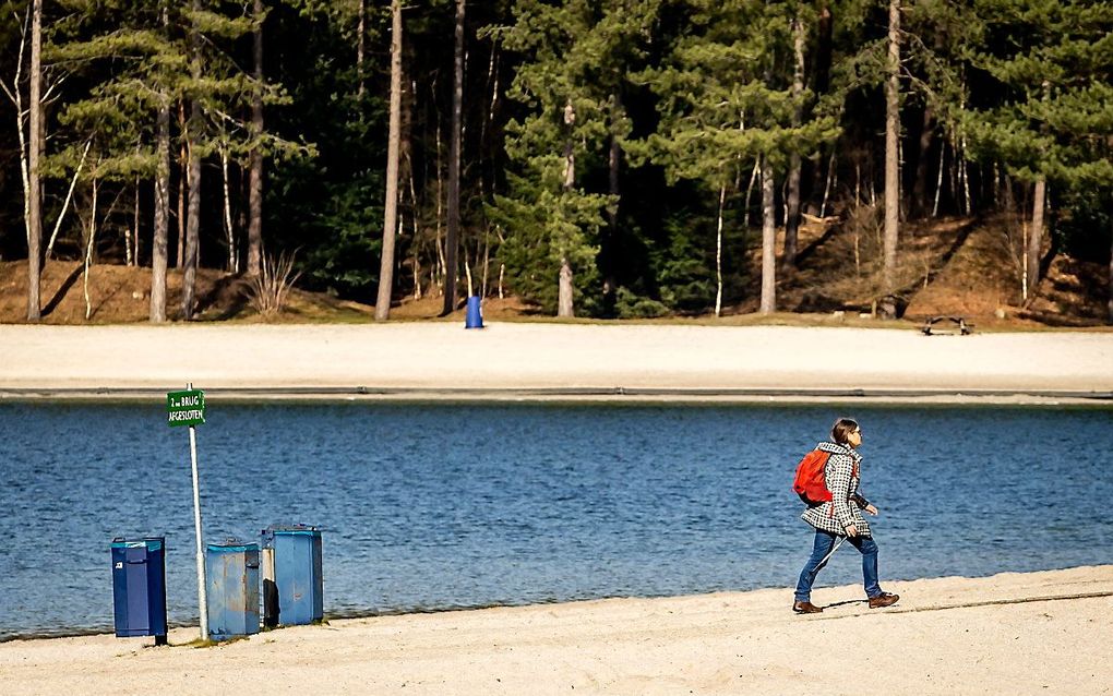 Een wandelaar geniet van het mooie weer afgelopen zaterdag bij het Henschotermeer in Woudenberg. beeld ANP