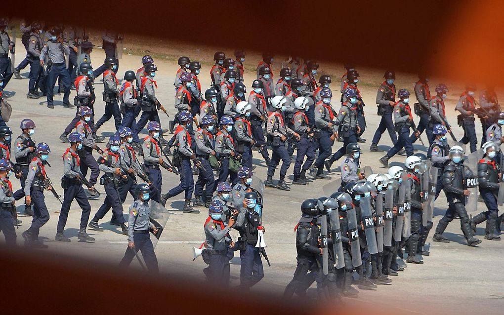 Agenten maken zich op om een einde te maken aan een protestbijeenkomst in Naypyidaw, de hoofdstad van Myanmar. beeld AFP