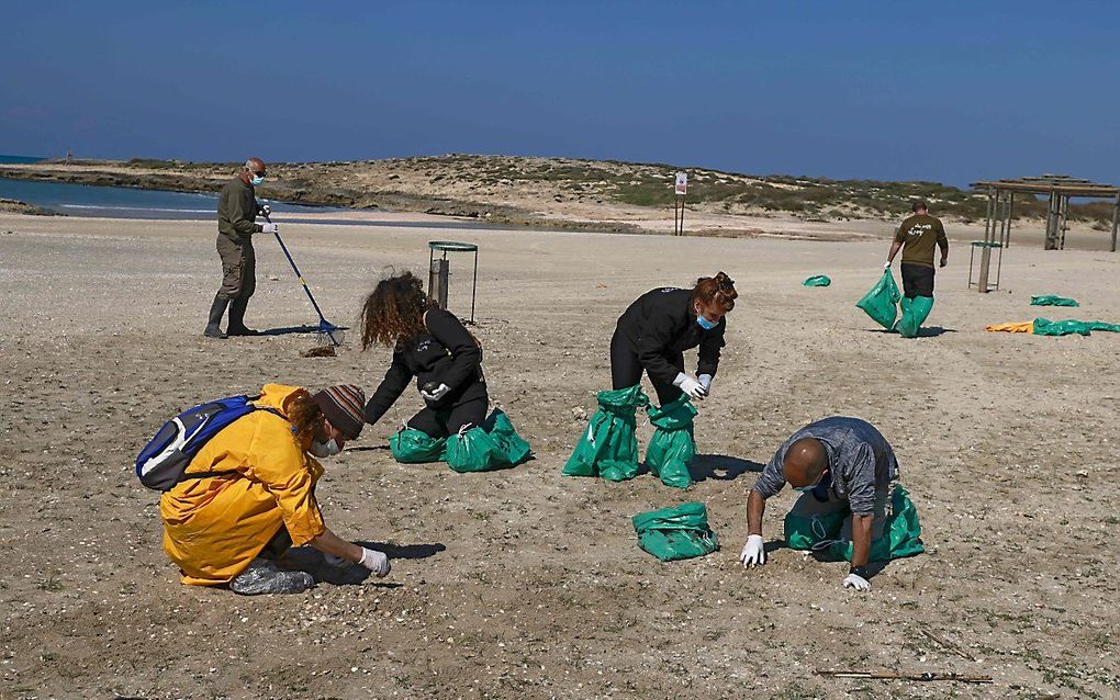 Schoonmaakwerkzaamheden op het strand van HaBonim, ten zuiden van Haifa. beeld AFP, MENAHEM KAHANA