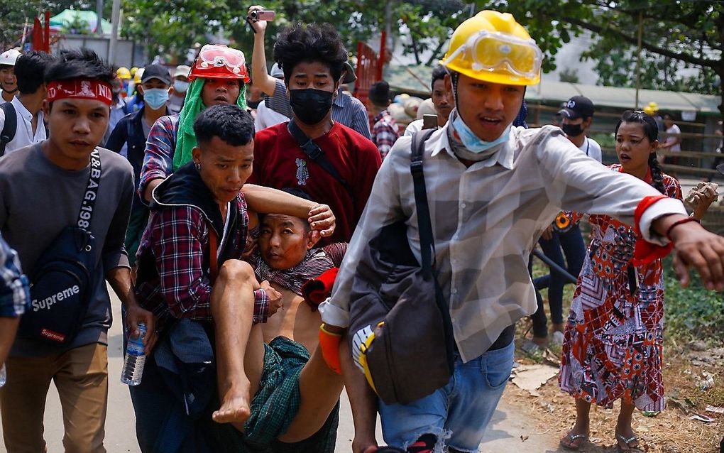 Een gewonden demonstrant wordt afgevoerd. beeld STR/AFP