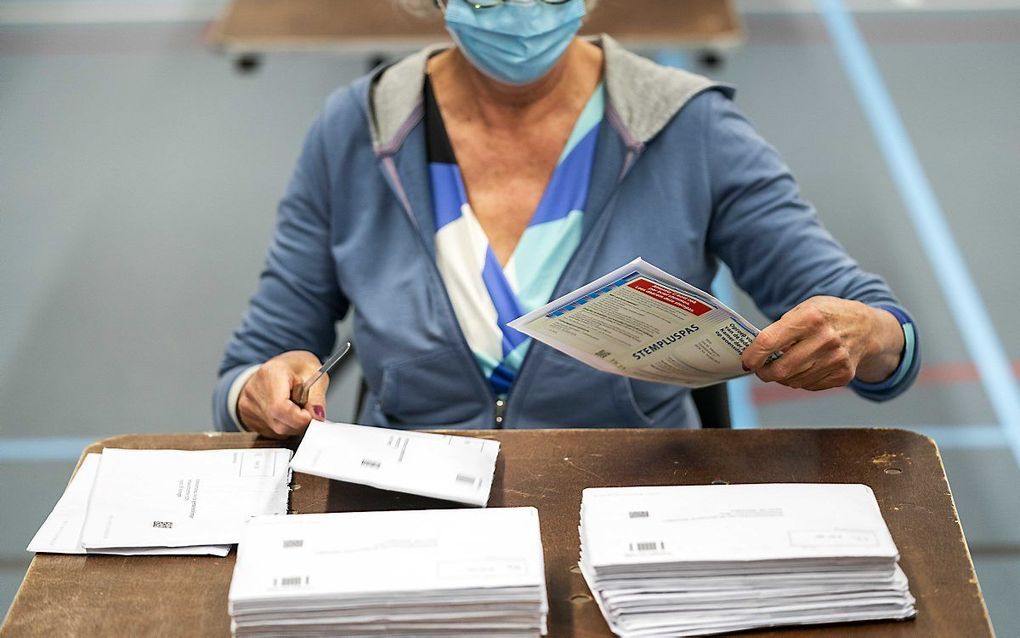 Briefstemmen voor de Tweede Kamerverkiezingen worden geopend en de stemmen worden in de stembussen gegooid in de Jan Massinkhal. Vanwege het coronavirus kunnen 70-plussers dit keer schriftelijk hun stem uitbrengen. beeld ANP, JEROEN JUMELET