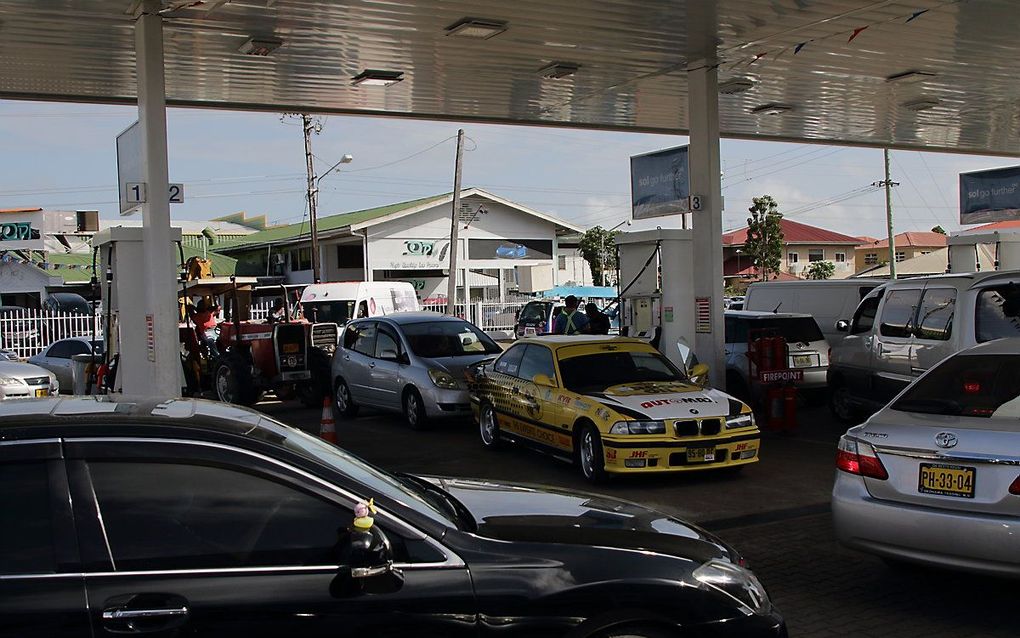 Surinamers in de rij voor het tankstation, in juli toen president Bouterse verscherpte maatregelen aankondigde. beeld ANP, Ranu Abhelakh