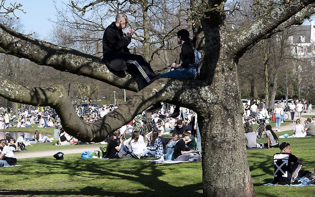 Bezoekers in het Vondelpark in Amsterdam. De toegang tot het park is dinsdag tijdelijk afgesloten omdat het te druk werd vanwege het mooie weer. beeld ANP EVERT ELZINGA