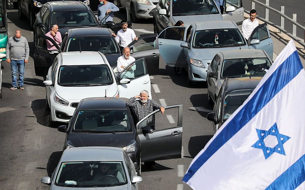 Automobilisten op een weg bij Jeruzalem stappen uit en houden een moment van stilte na het geloei van de sirenes. beeld EPA, Abir Sultan