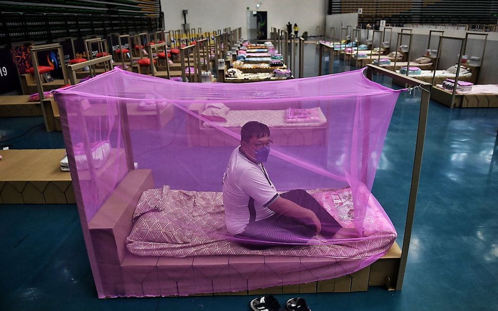 Een gezondheidsmedewerker test een bed voor coronapatiënten in een veldhospitaal in Bangkok. beeld AFP, Lillian SUWANRUMPHA