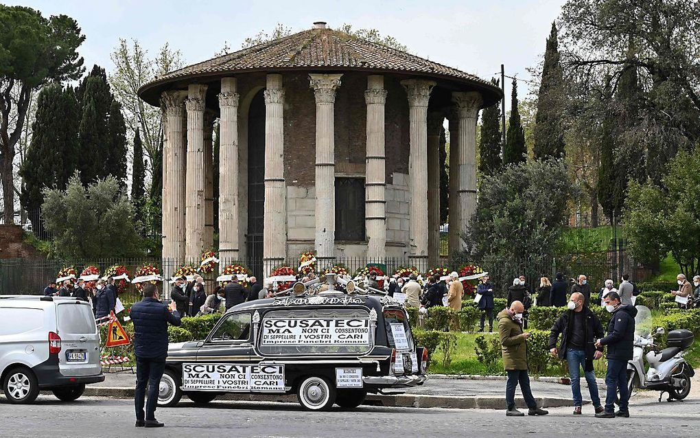 Protest uitvaartsmedewerkers in Rome, vorige week. beeld AFP, Andresas Solaro


A hearse with a placard that reads "Apologies but they don't let us bury your loved ones" is parked close to funeral home workers protesting at the ancient Roman "Hercules the Winner" circular temple against the disruption of funeral services due to the increasing number of deaths caused by the Covid-19 on April 16, 2021. (Photo by Andreas SOLARO / AFP)