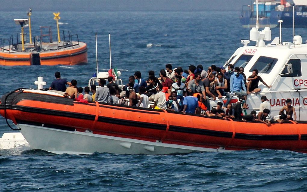 Een patrouilleboot van de Italiaanse kustwacht begeleid een boot met migranten naar de Siciliaanse haven van Palermo. beeld AFP, Alessandro Fucarini