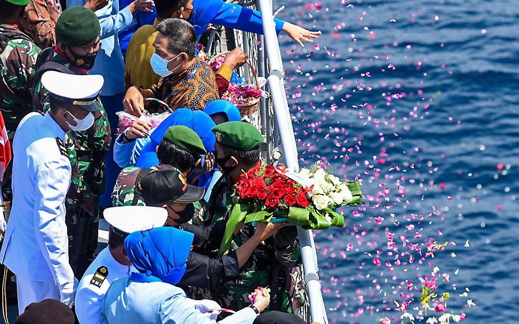 Nabestaanden gooien bloemen in zee om de bemanningsleden van de gezonken onderzeeër te herdenken. beeld EPA, Atmaja