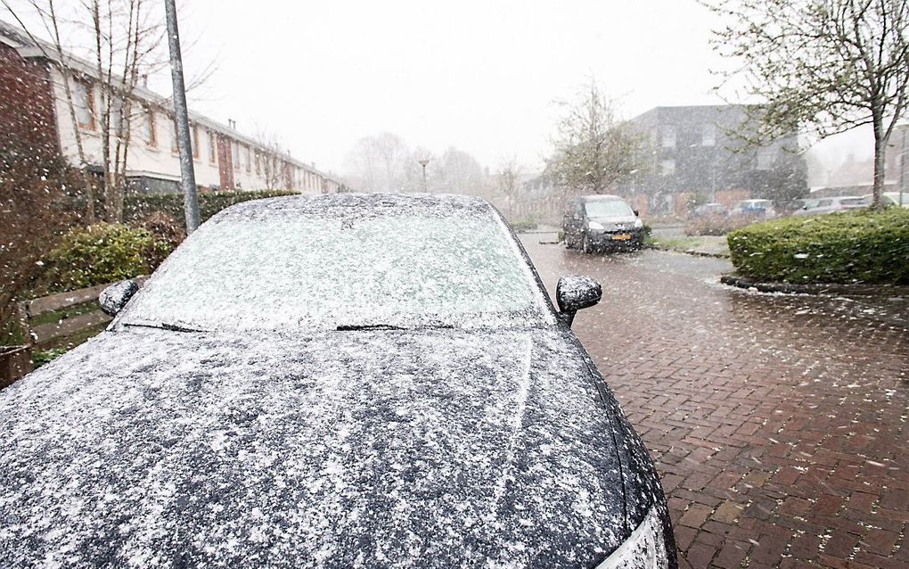 Een straat kleurt wit in een Groningse woonwijk. Voor het eerst sinds jaren had Nederland een witte Pasen. Naast de winterse buien waaide het ook stevig. beeld ANP, Venema Media